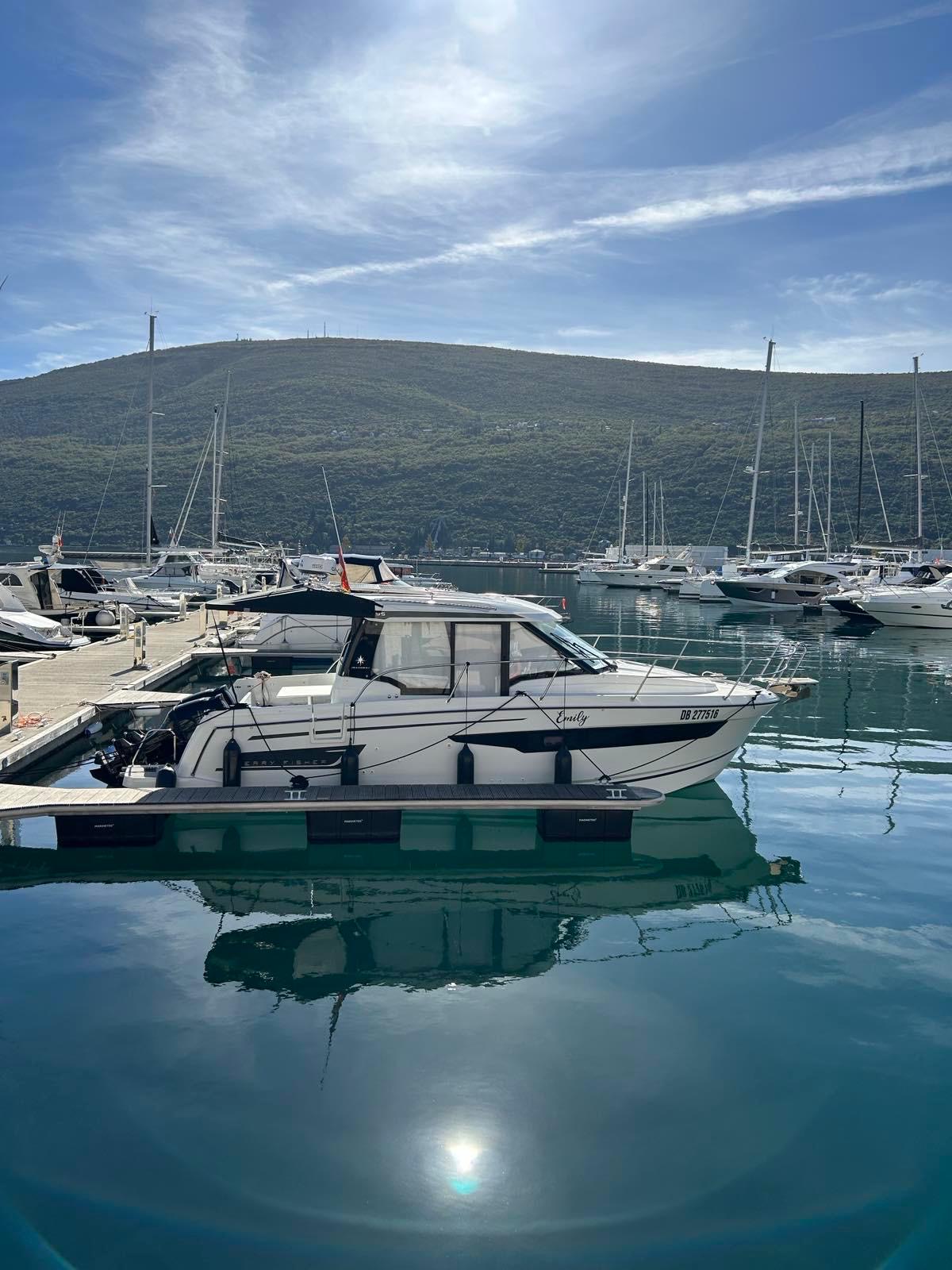 Jeanneau Merry Fisher 895 2022 moored in a serene marina, reflecting stunning surroundings.